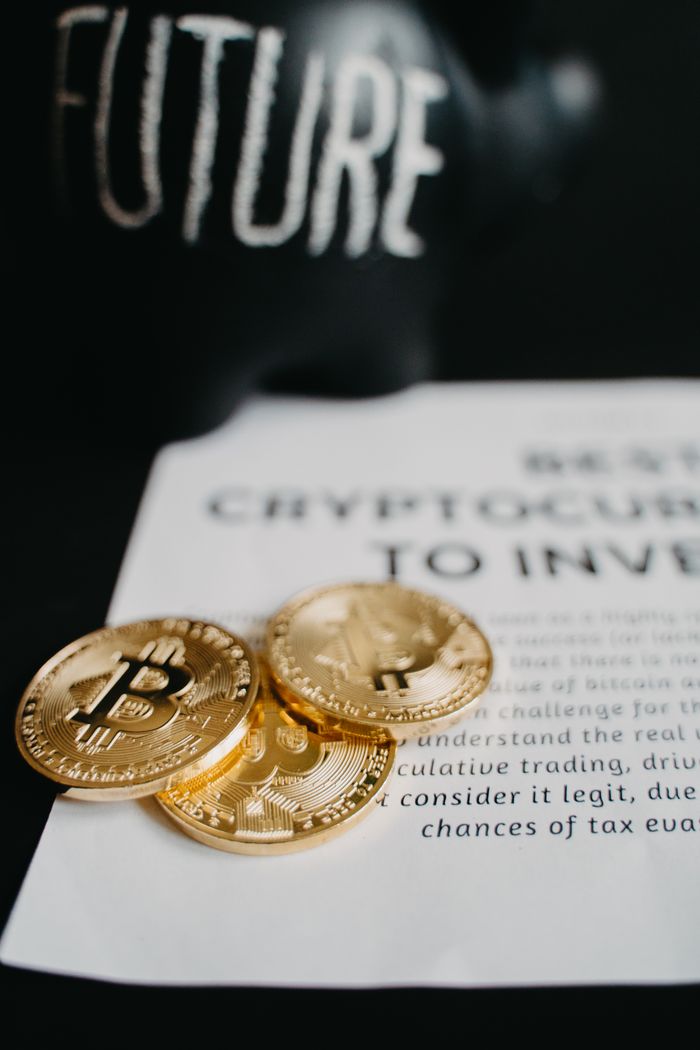 About Focus on gold Bitcoin coins atop an investment article with future-themed decor.